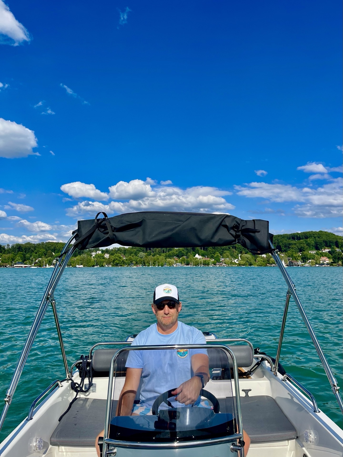 Pascal am Steuer des Elektroboots auf dem karibisch türkisen Wörthsee